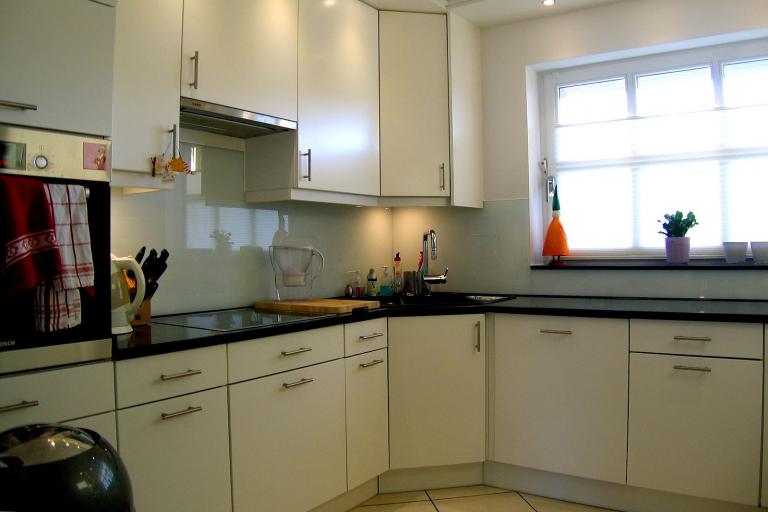 Einbauküche mit weißen Fronten und dunkler Arbeitsfläche