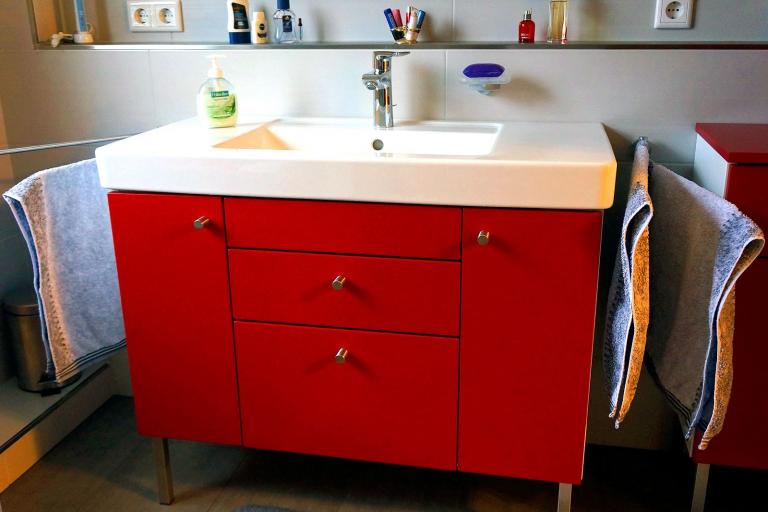 Roter Waschtisch mit weißer Platte und versenktem Waschbecken