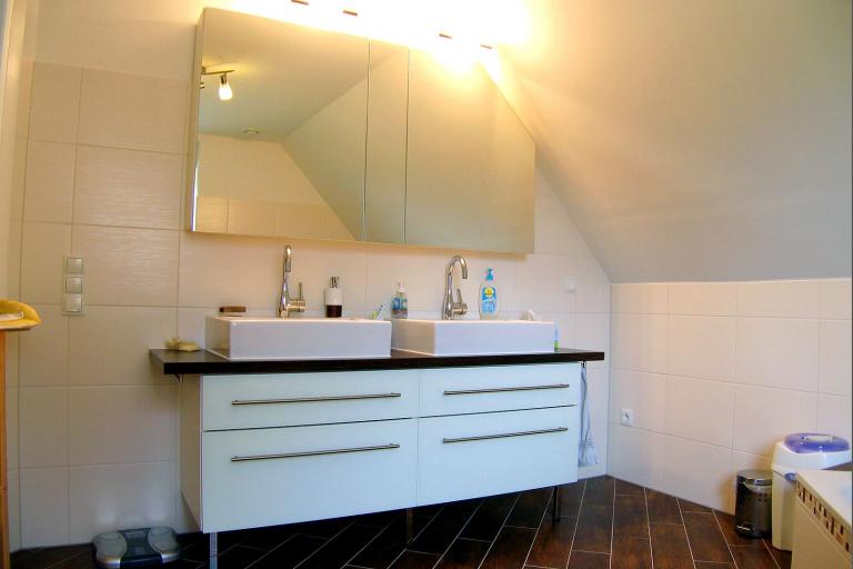 Waschtisch mit Schubladen, weißer Front, dunkler Platte und zwei aufgesetzten Waschbecken