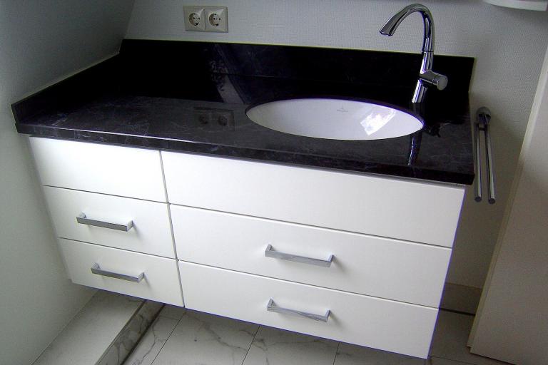 Waschtisch mit schwarzer Steinplatte und weißen Fronten
