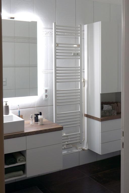 Waschtisch mit weißer Front, Schubladen, Fächern, Holzplatte. aufgesetztem Waschbecken und Hängeschrank