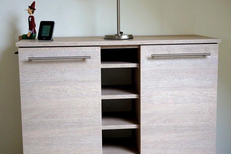 Flurkommode aus hellem Holz mit zwei Türen und fünf offenen Fächern