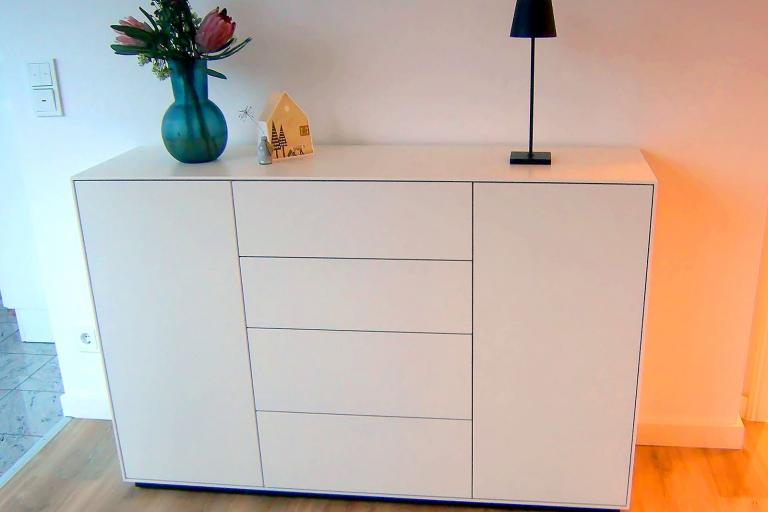 Weiße Kommode mit zwei Türen und vier Schubladen ohne Griffe