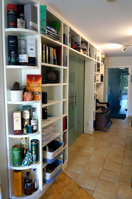 Elegantes Wohnzimmer-Regal mit abgerundeten Eckfächern und Durchgang