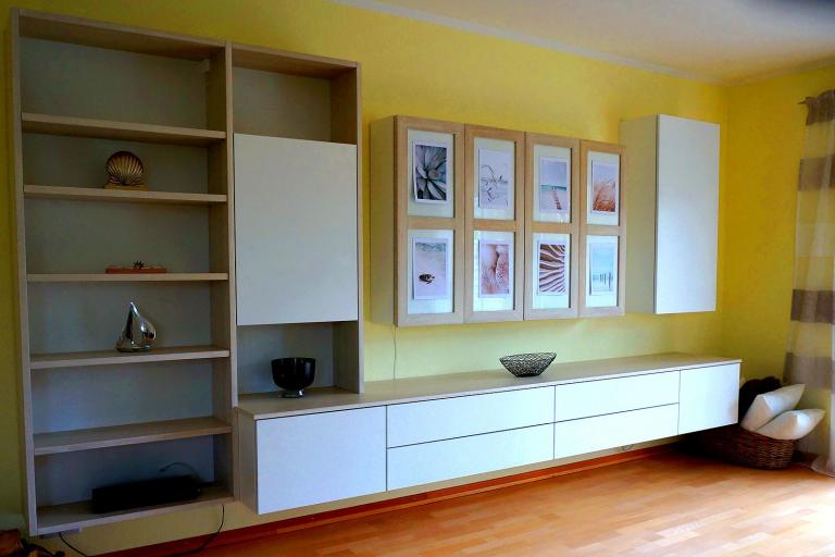 Echtholz-Wohnwand mit Lowboard, Regalen und Hängevitrine mit weißen Fronten