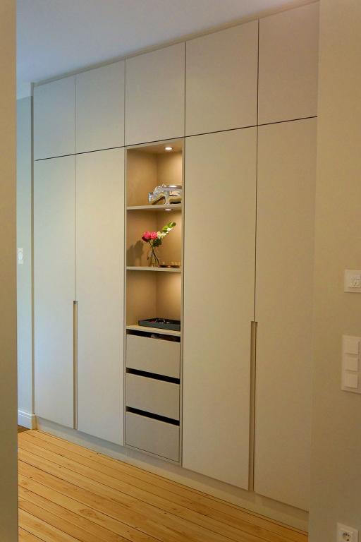 Großer Kleiderschrank mit weißen Fronten, Schubladen und beleuchteten Deko-Fächern