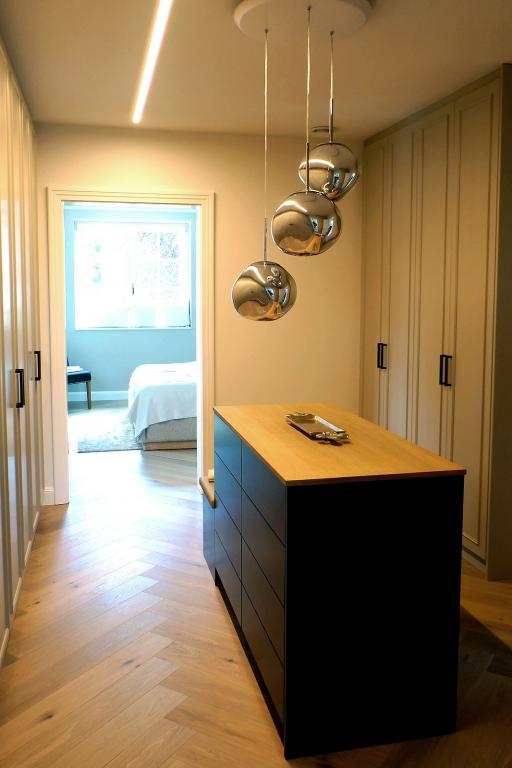 Ankleidezimmer mit großen Kleiderschränken und Schubladen-Insel