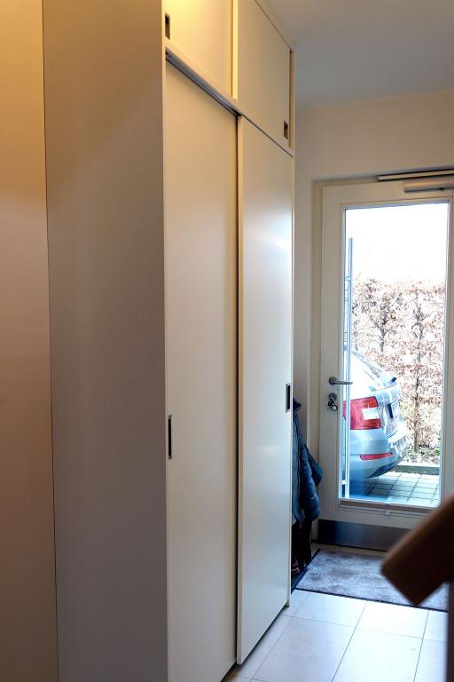 Weißer, deckenhoher Flurschrank als Garderobe