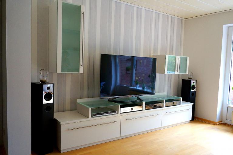 Weiße Wohnwand aus Lowboard und Hängevitrinen mit Glasfronten