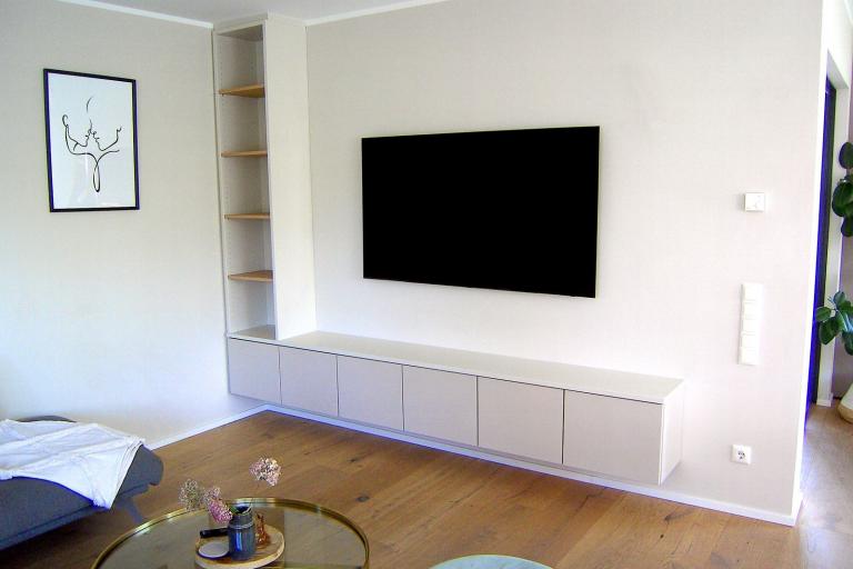Weißes Sideboard mit Regal unter hängendem TV-Gerät