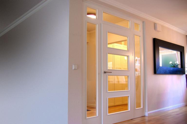 Weiß lackierte Innentür mit Glasfenstern und Metallgriff